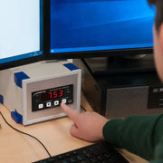 Οθόνη πεχάμετρου PCE Instruments PCE-PHC 10 με κόκκινη ένδειξη 7.53 και πλήκτρα, σε γραφείο με οθόνες PC