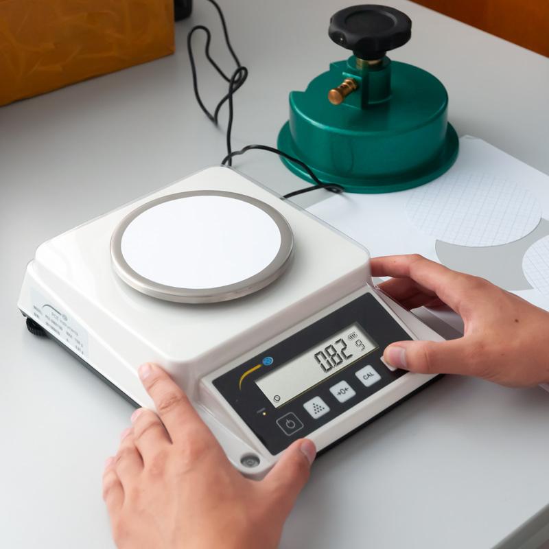 Ζυγός χαρτιού PCE Instruments PCE-DMS 1100 με στρογγυλή πλατφόρμα και ψηφιακή οθόνη, σε χρήση σε πάγκο
